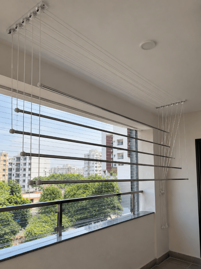Ceiling-mounted pulley clothes drying rack on a sunlit balcony